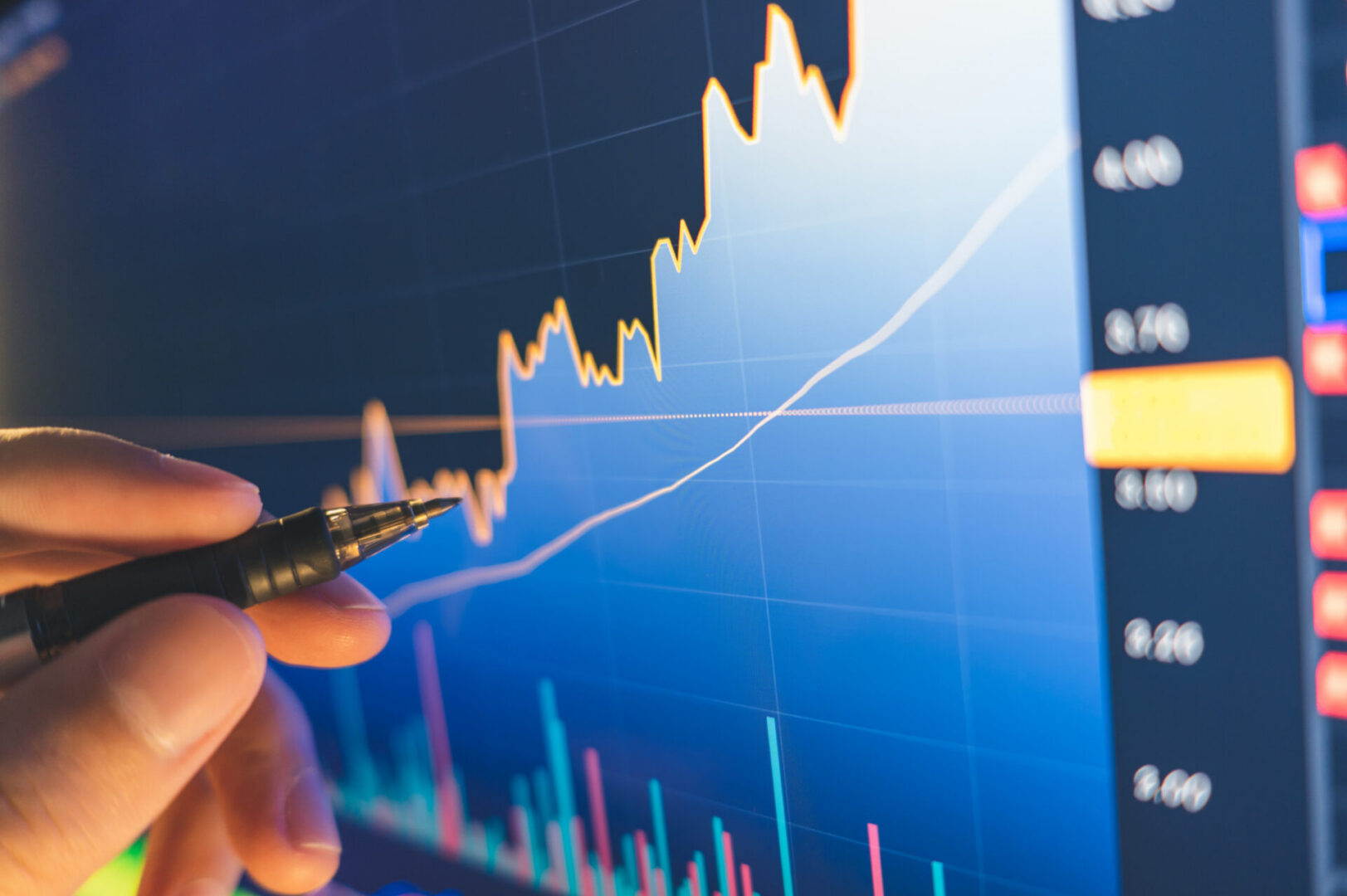 Analyzing financial graph on computer screen.