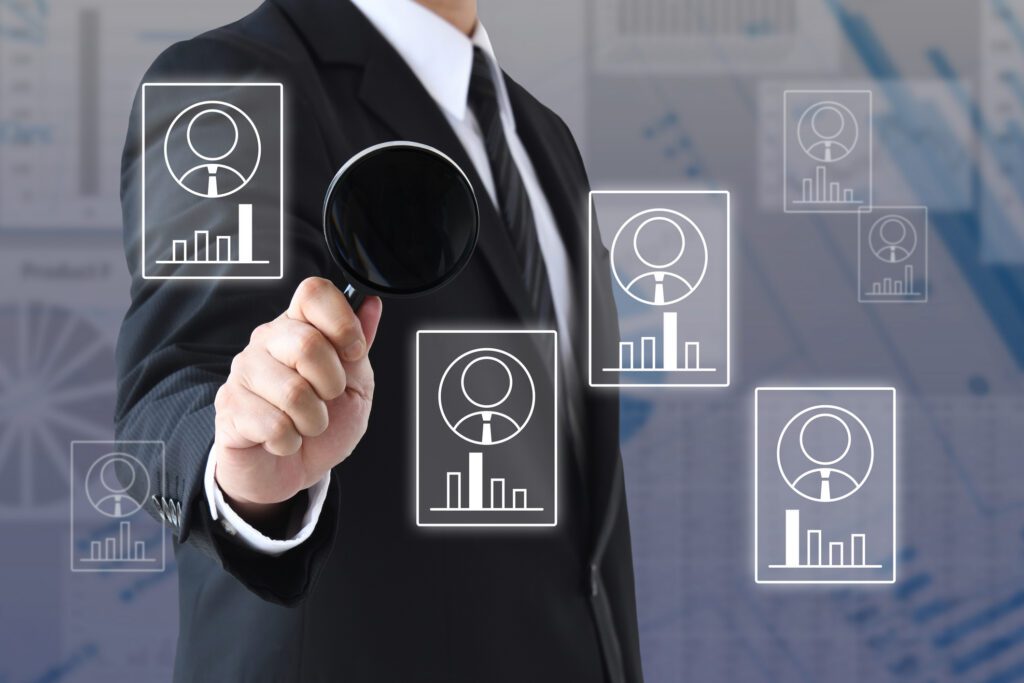 Businessman analyzing data with magnifying glass.