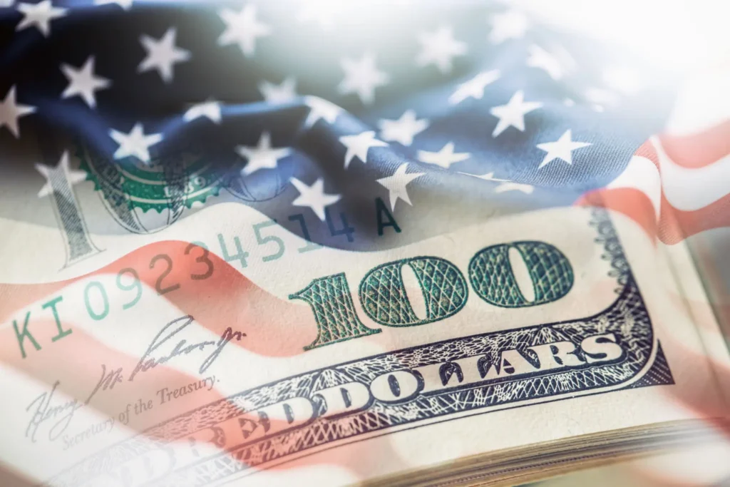 American flag overlaid on one hundred dollar bill